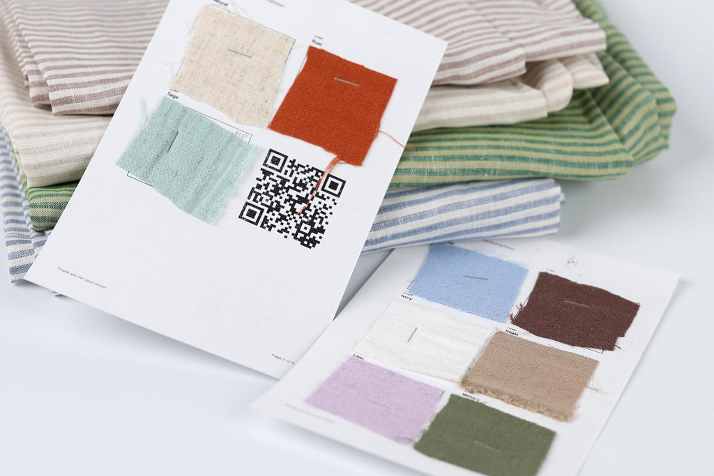 a collection of fabric swatches and a printed paper with a QR code, likely used for selecting fabric colors or patterns.