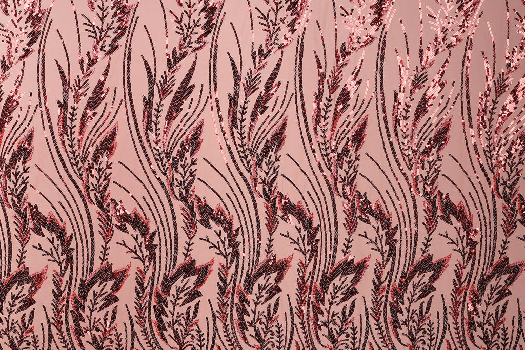 a close-up view of a fabric with a repeating pattern of red and black sequin designs. The pattern consists of long, thin lines that create a repeating floral or leaf-like design. The fabric appears to be a pinkish-red color, and the sequin designs are visible throughout the entire image.