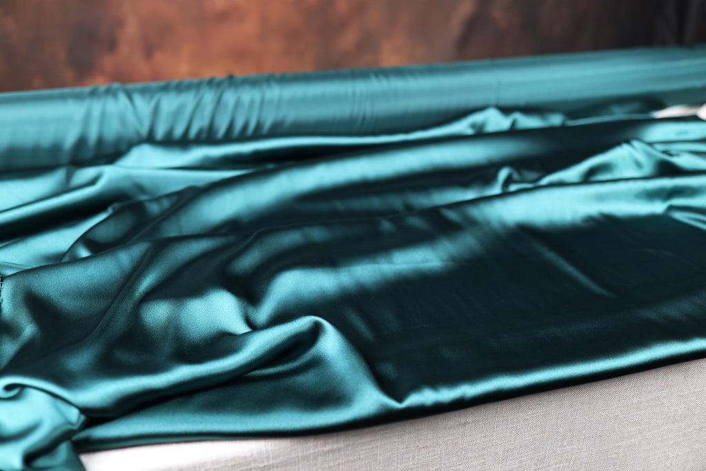 a close up of a green cloth on a bed