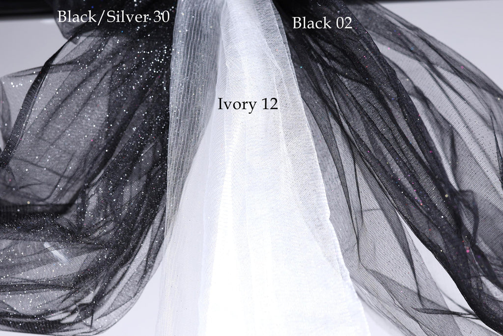 a close-up view of a black and white fabric, possibly a sheer or sheer-like material, with a text overlay indicating the color and material of the fabric.