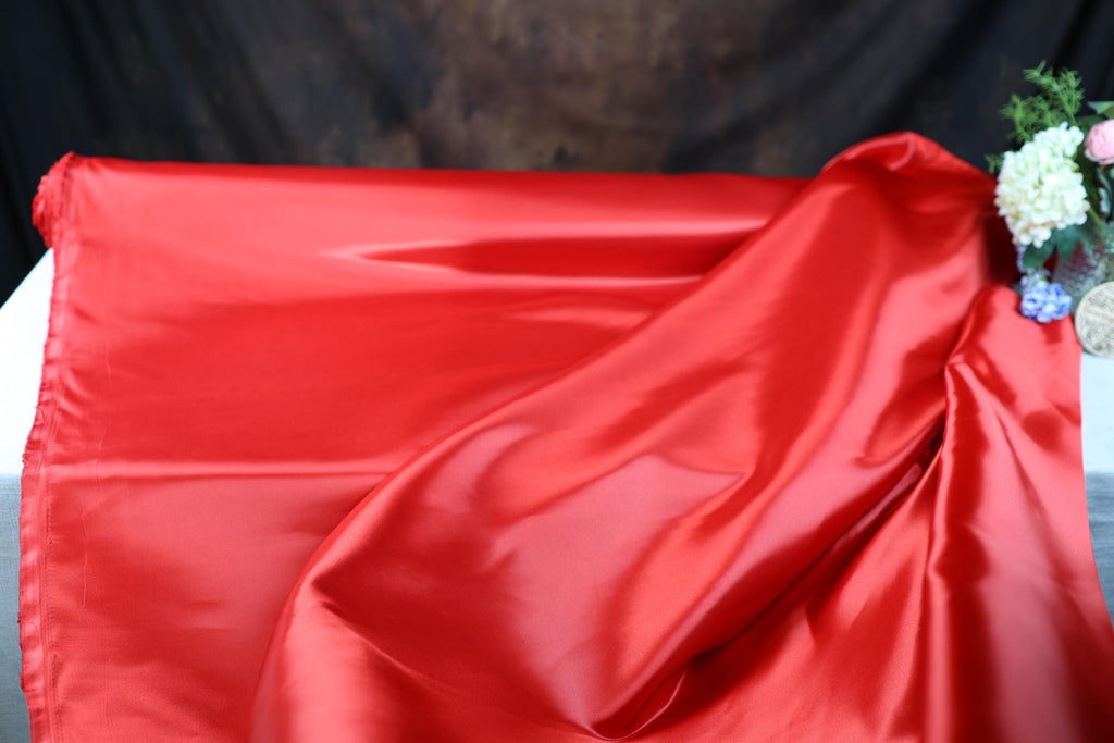 a close up of a red cloth with flowers on it