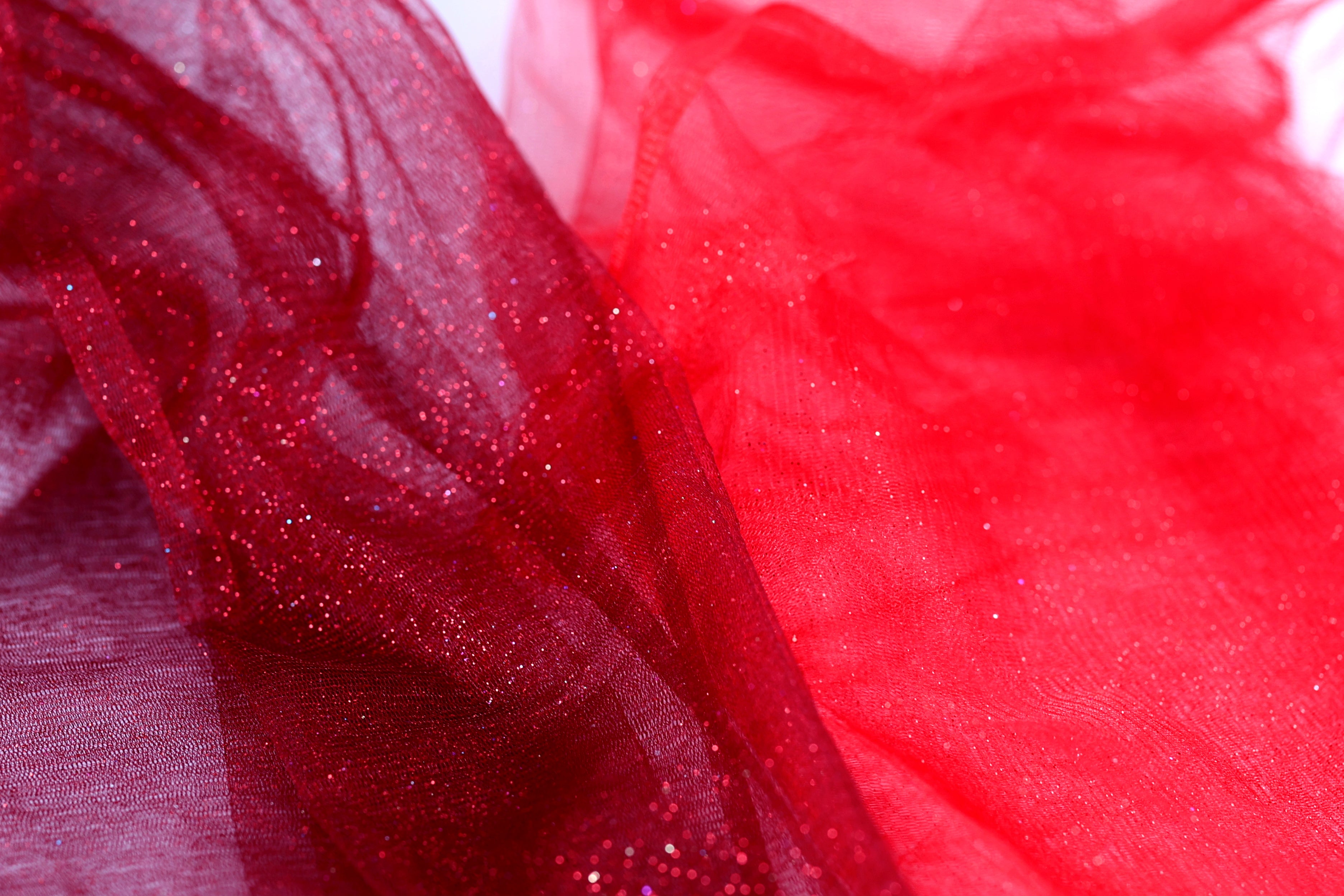 a close-up view of a red fabric with a glittery texture, creating a visually striking contrast.