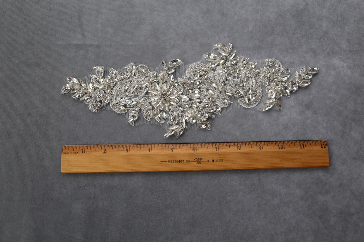 a ruler is next to a piece of silver sequins