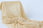 a piece of light-colored fabric, possibly a sheer or sheer-like material, draped over a surface.