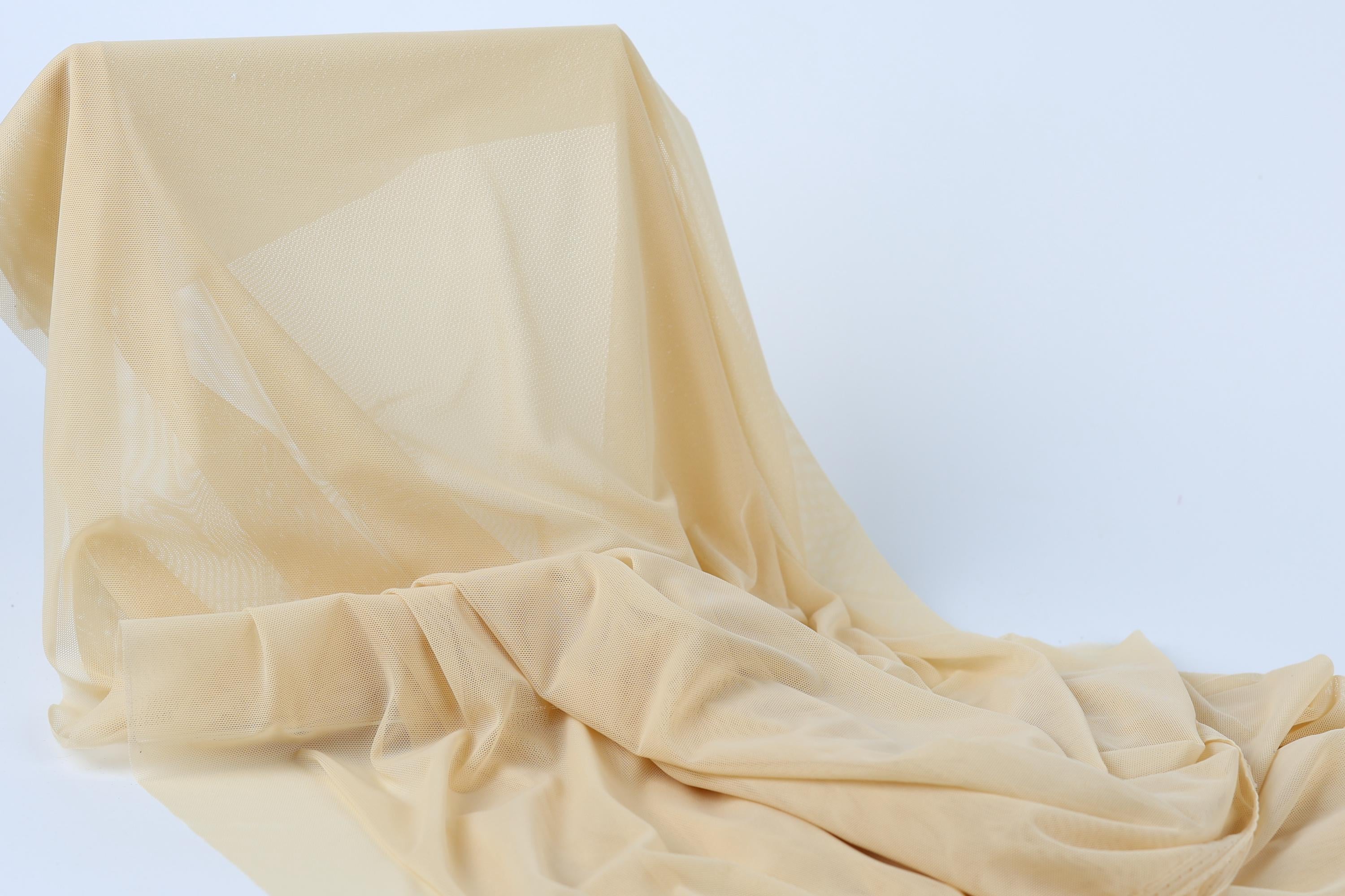 a piece of light-colored fabric, possibly a sheer or sheer-like material, draped over a surface.