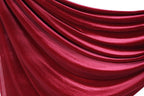 a close-up view of a red velvet curtain, with its folds and creases visible.