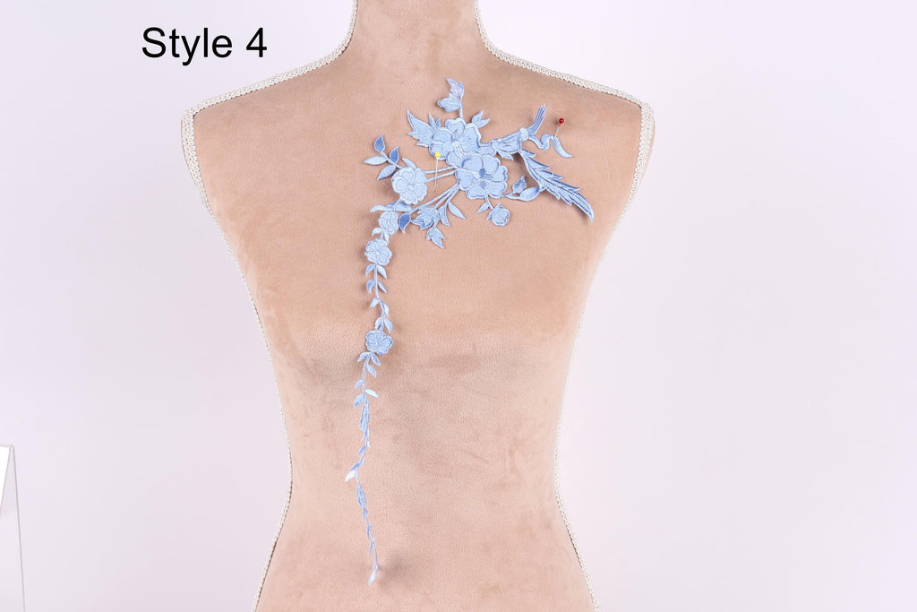 A mannequin with a blue floral embroidered on its back, featuring a long, delicate flower design.