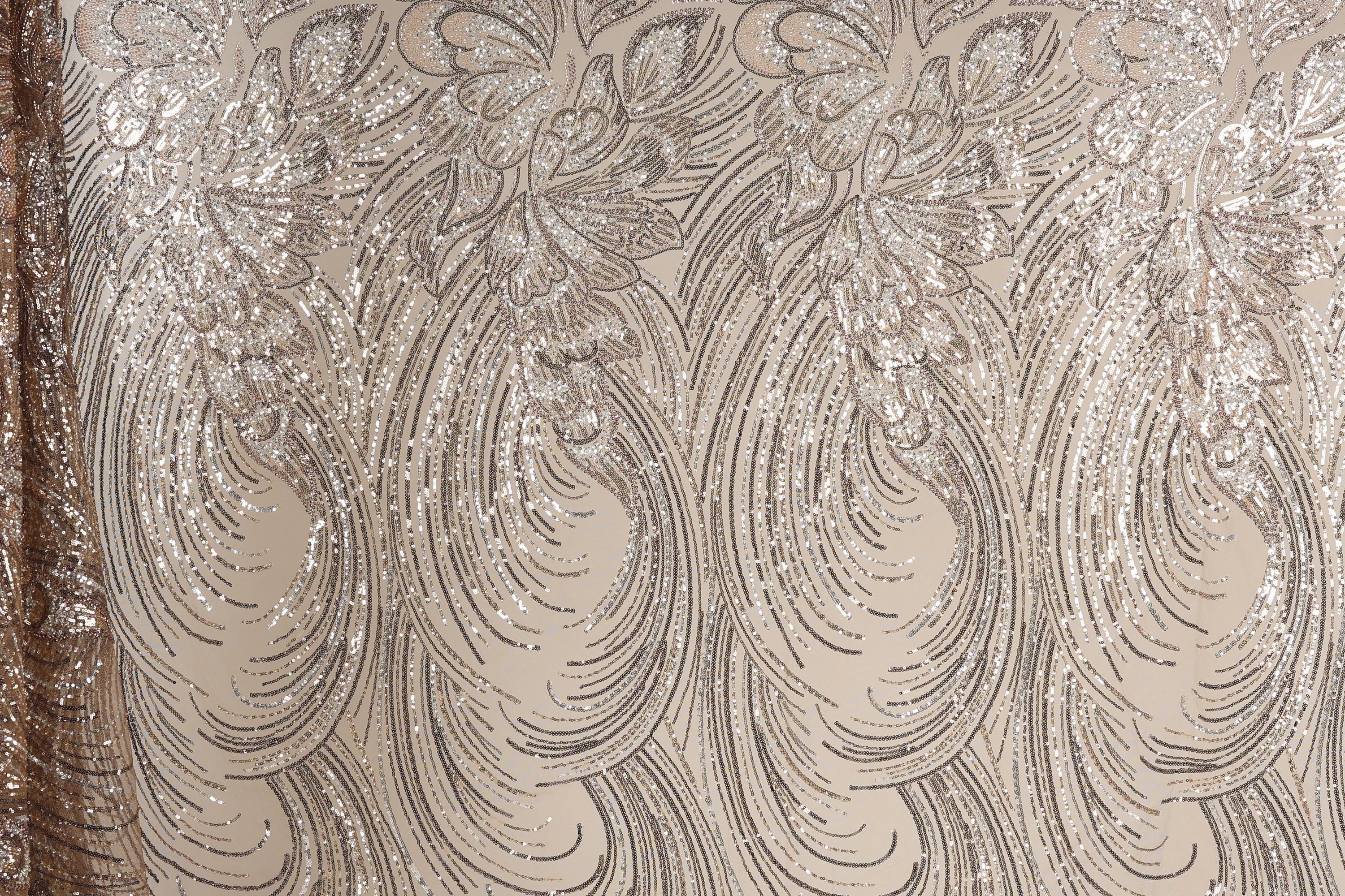 a close-up view of a fabric with a repeating pattern of swirls and lines in shades of brown and beige. The pattern appears to be made of sequin or glitter, giving it a shiny and textured appearance.