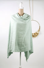 A light green shawl draped over a mannequin torso, displayed on a white mannequin stand.