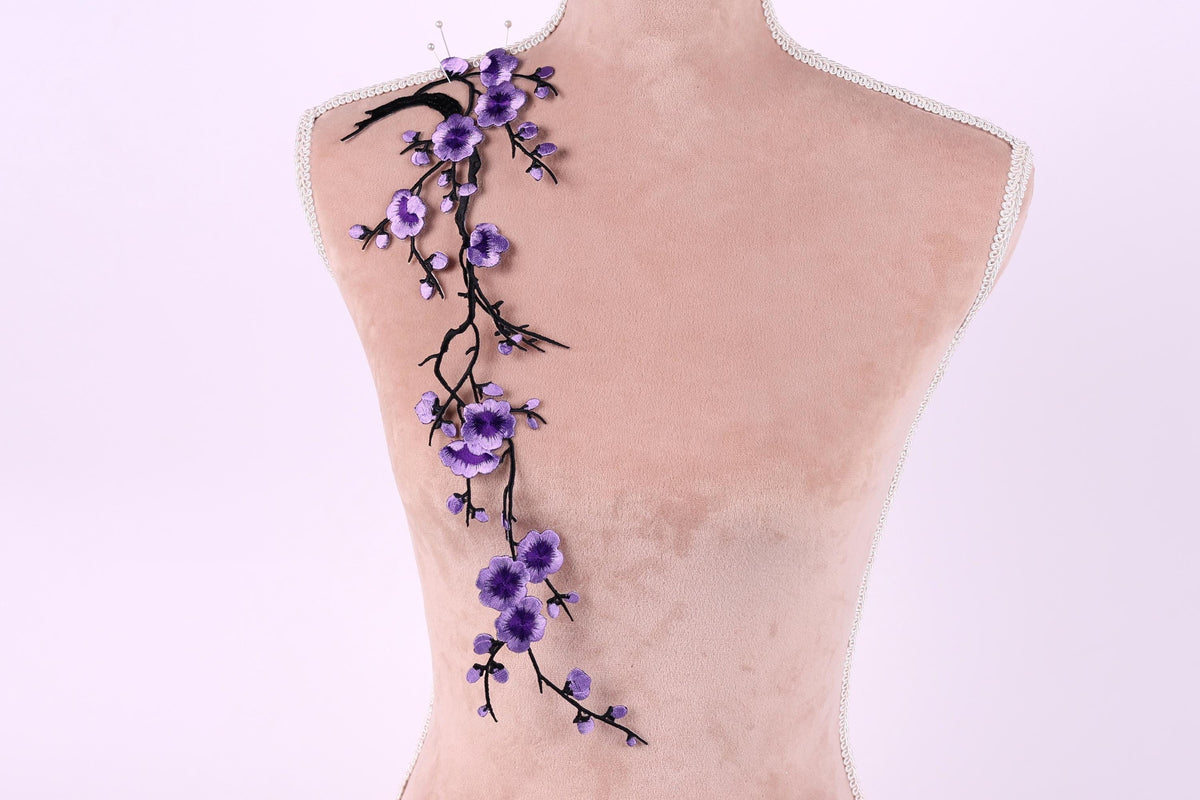 a mannequin with purple flowers attached to its back.