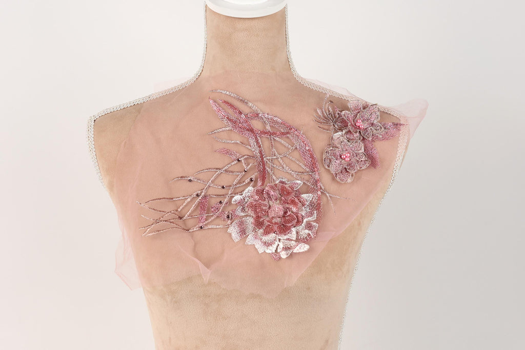 A mannequin with a pink floral design on its bust, featuring a large pink flower and smaller pink flowers.