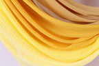 a close-up view of a fabric with a vibrant yellow and orange gradient, creating a visually striking and dynamic composition.