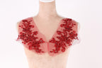 A mannequin wearing a red, sheer collar with intricate floral embroidery.