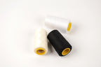 three spools of thread, including white, black, and yellow, arranged on a white background.