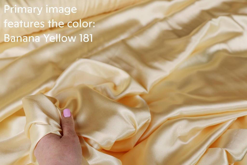 a hand holding a piece of fabric with a yellow color, which appears to be a fabric material.