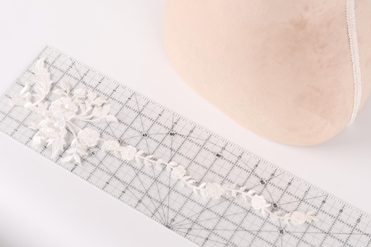a close-up view of a ruler with a delicate floral pattern on it, placed next to a beige object.