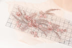 a decorative arrangement of pink flowers and leaves on a transparent ruler, creating a visually appealing and intricate design.