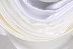 The image is a close-up of a white fabric, possibly silk or satin, with a soft, flowing texture.