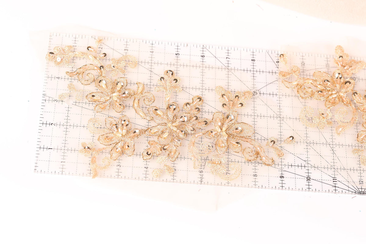a clear ruler with gold-colored floral designs placed on it.