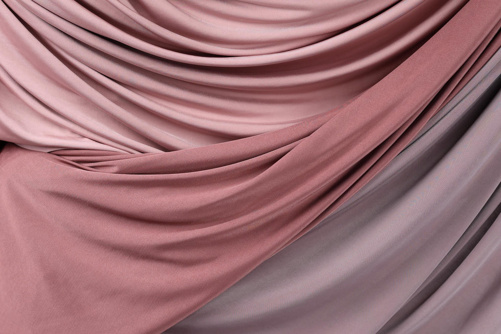 a close-up view of a fabric with a soft, flowing texture in shades of pink and gray.