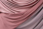 a close-up view of a fabric with a soft, flowing texture in shades of pink and gray.