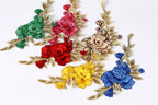 a collection of colorful floral embroidery pieces, including red, pink, yellow, blue, and green flowers, arranged on a white background.