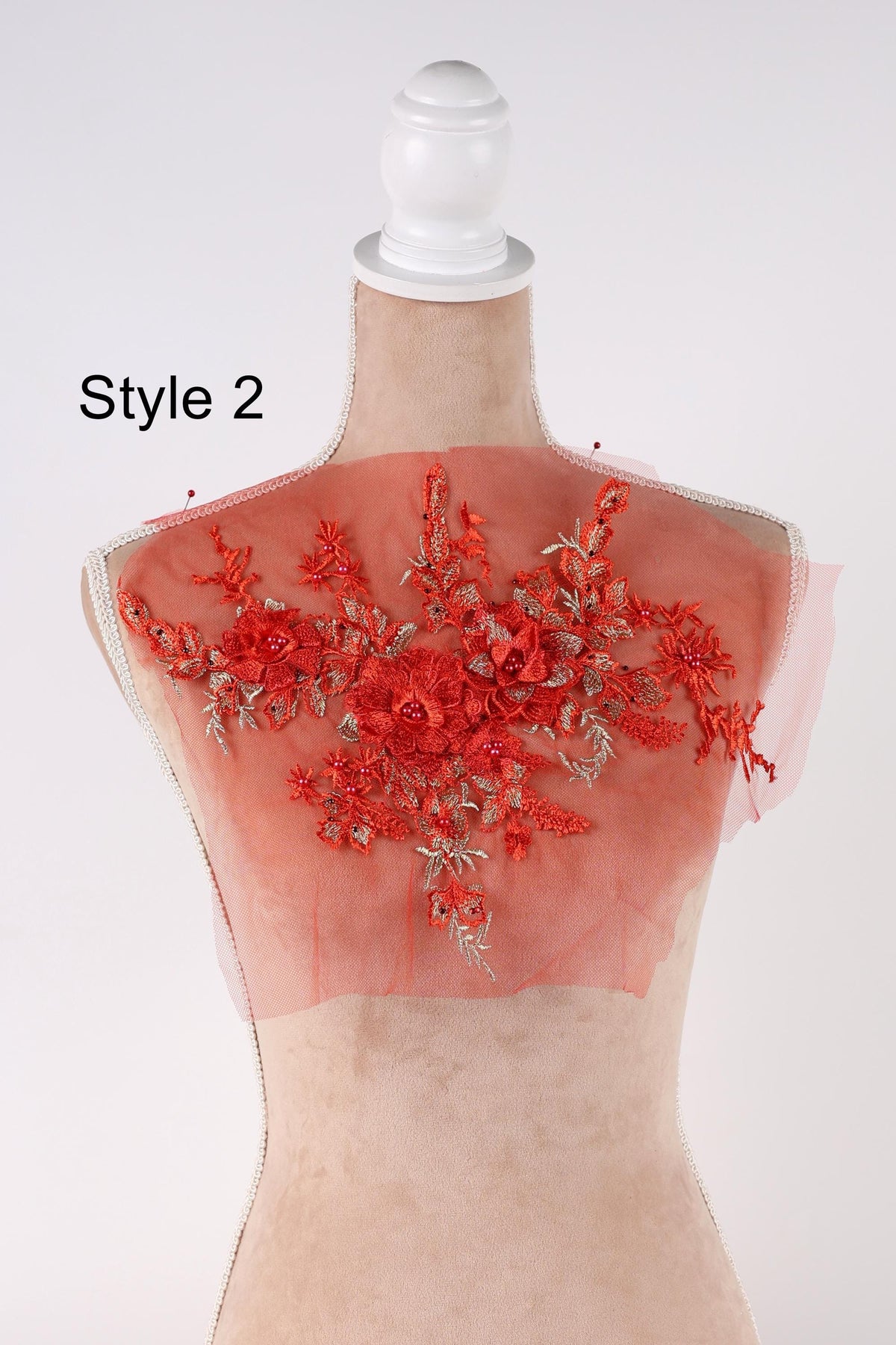 A mannequin with a red floral embroidered on its back, displayed against a white background.