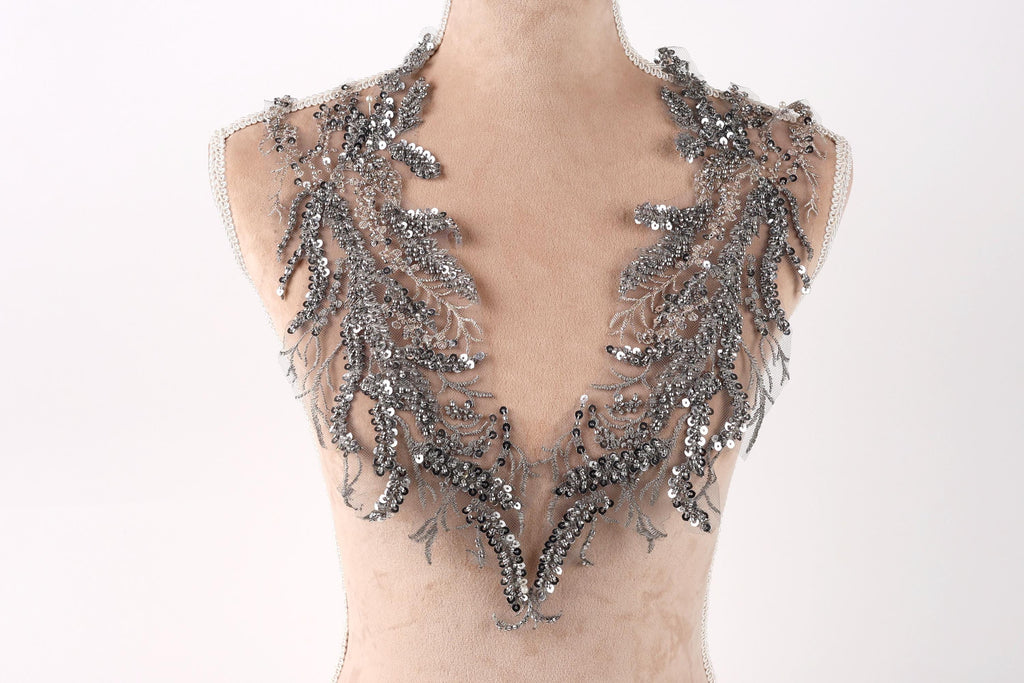 A mannequin wearing a silver sequin and lace neckline.