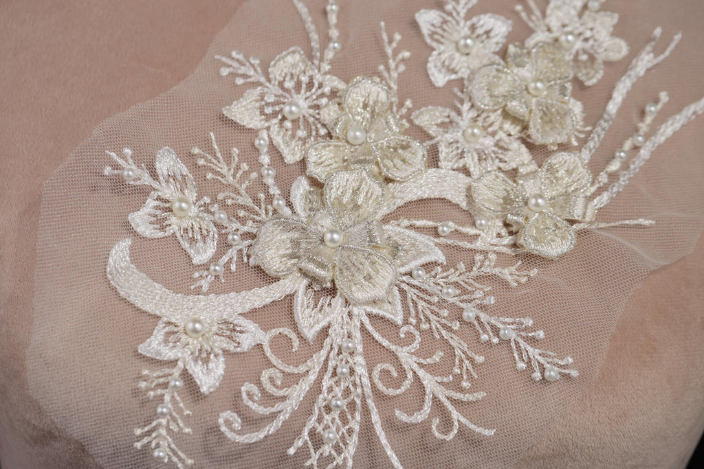 a close-up view of a delicate, intricate piece of lace or fabric adorned with a floral pattern. The lace features numerous small flowers and leaves, creating a visually appealing and delicate design.