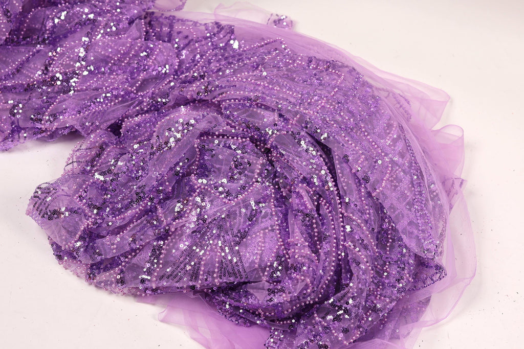 a close-up view of a piece of purple fabric with a glittery, sequined texture.