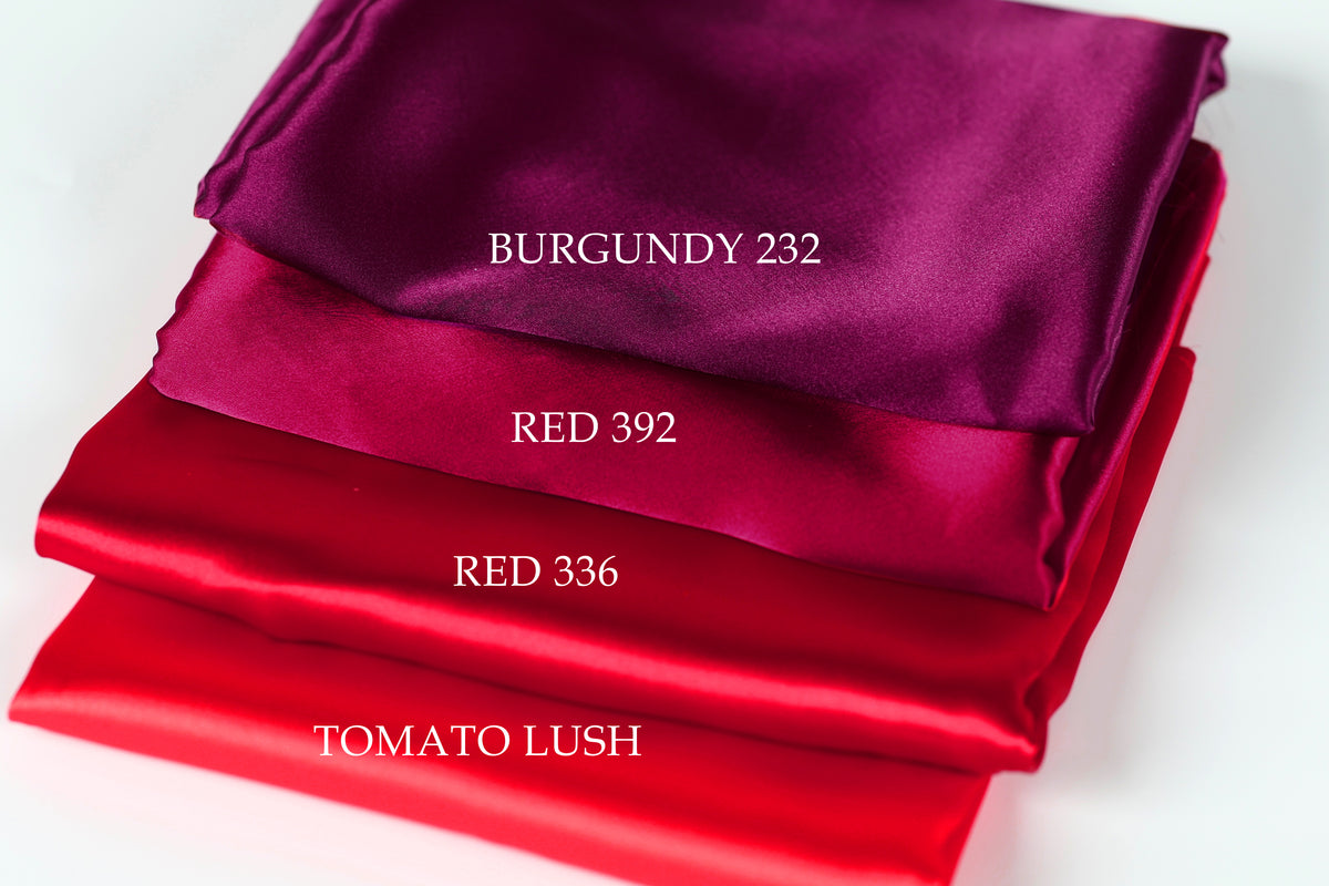 a stack of four fabric swatches, each with a different color: burgundy, red, red, and tomato lush.