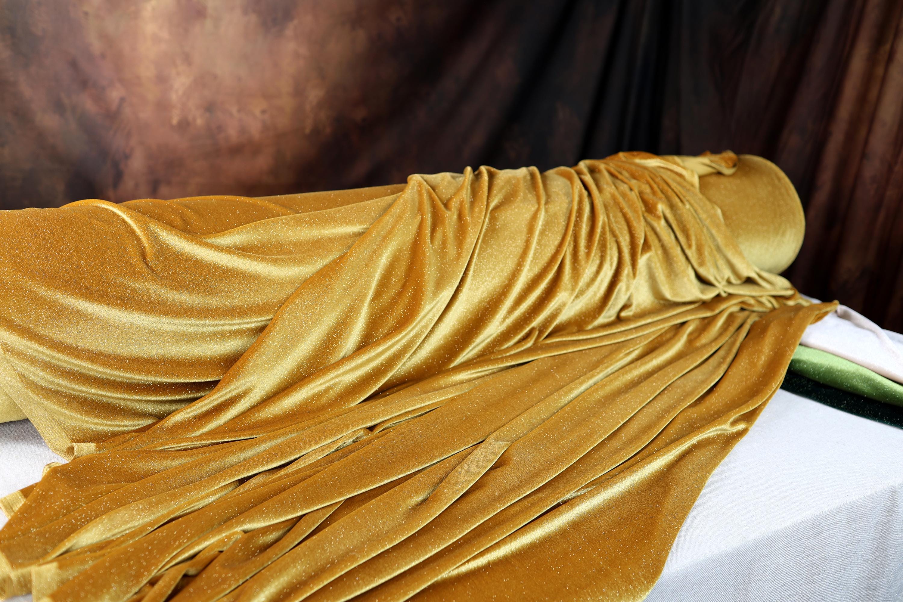a woman laying on top of a bed covered in a yellow blanket