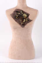 a mannequin with a decorative flower embroidered on its bust.