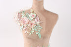A mannequin with a floral design on its shoulder, featuring pink and green flowers and leaves.