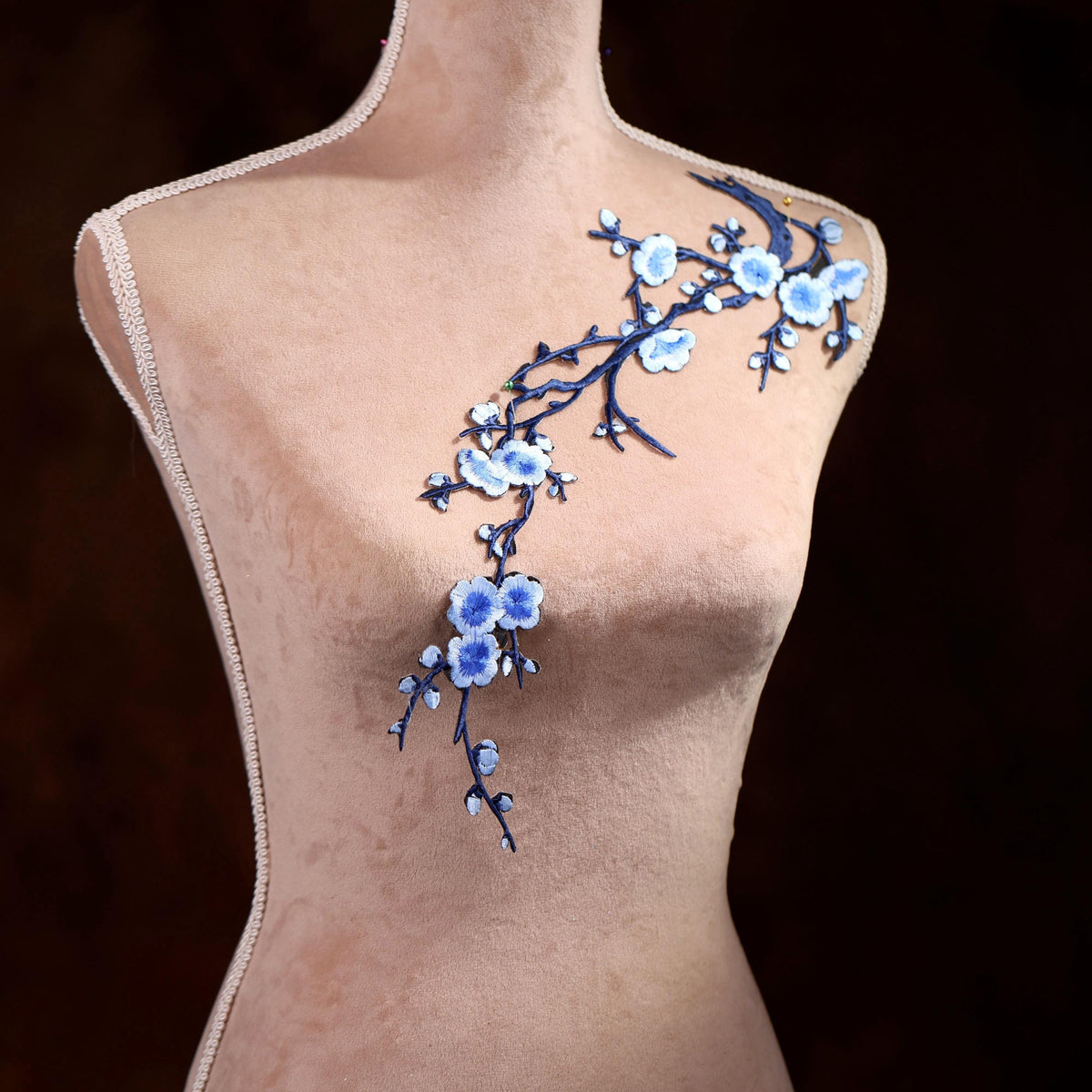 A mannequin with a delicate floral embroidery on its shoulder.