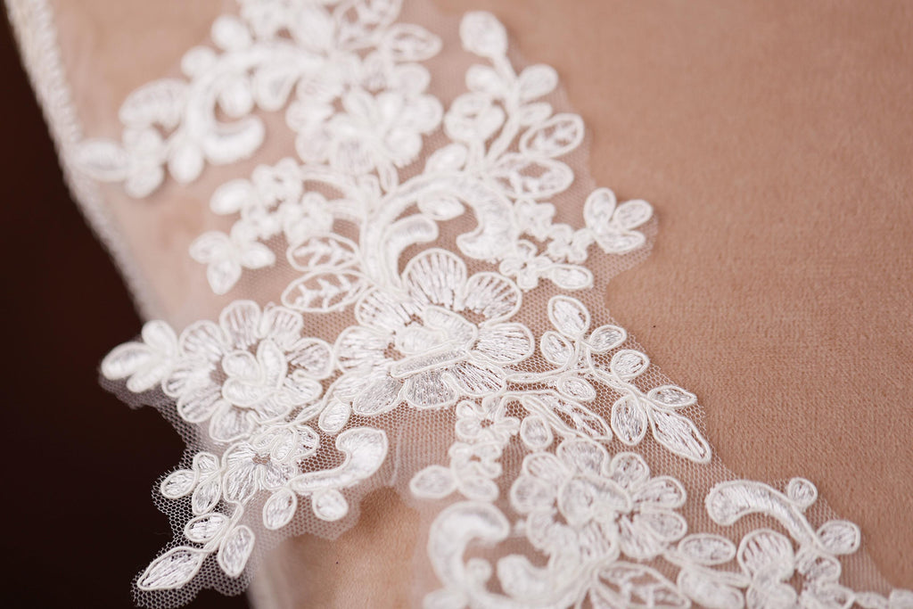 a close up of a white lace on a pillow