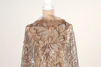 A mannequin wearing a gold and brown sequined dress with a ruffled collar.