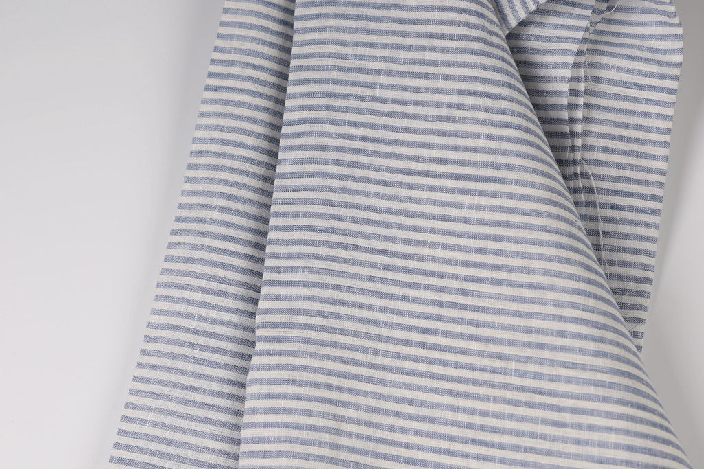 A close-up view of a fabric with a striped pattern in shades of blue and white.
