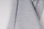 A close-up view of a fabric with a striped pattern in shades of blue and white.