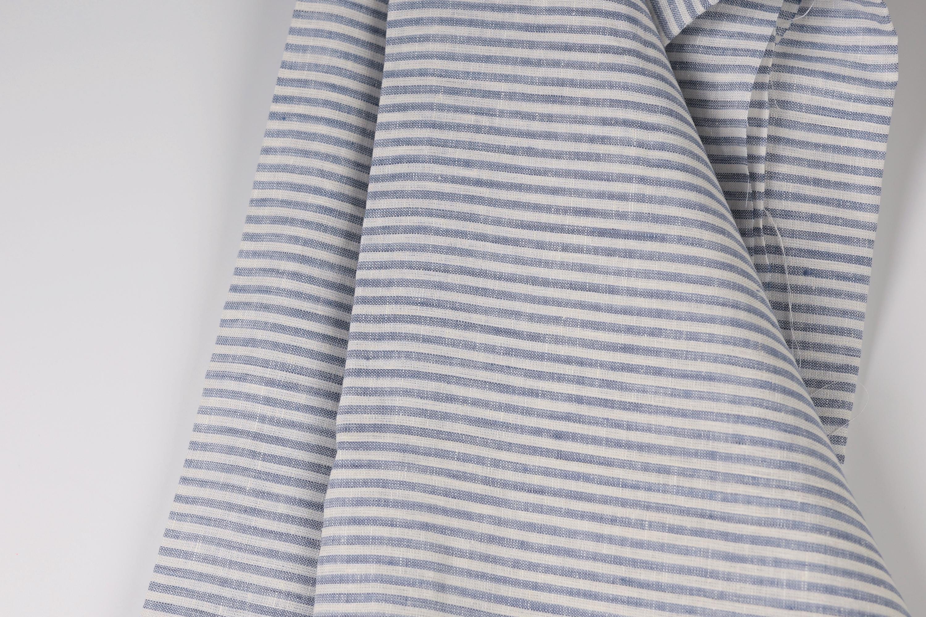 A close-up view of a fabric with a striped pattern in shades of blue and white.