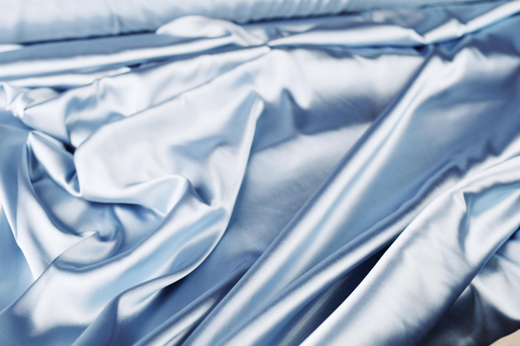 a close up of a bed with blue sheets