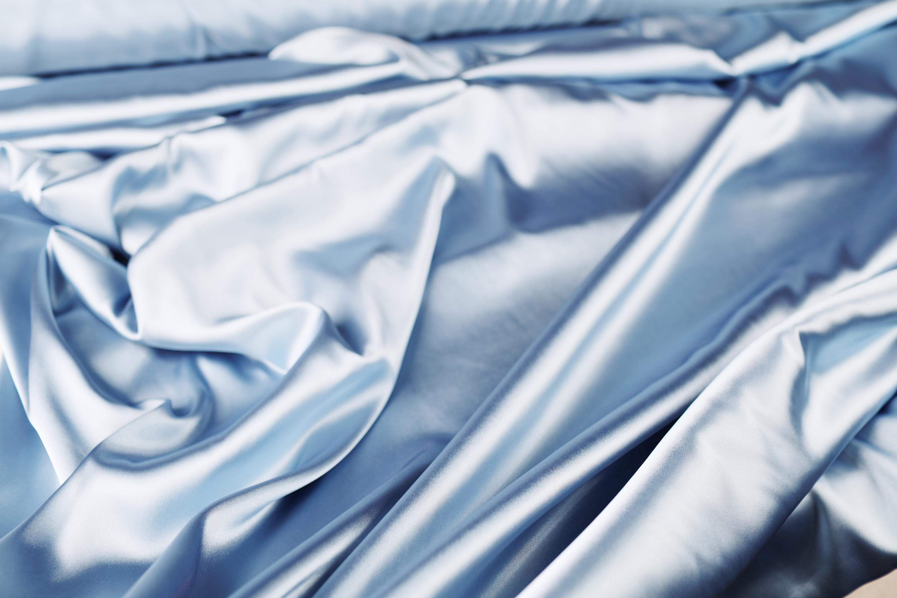 a close up of a bed with blue sheets