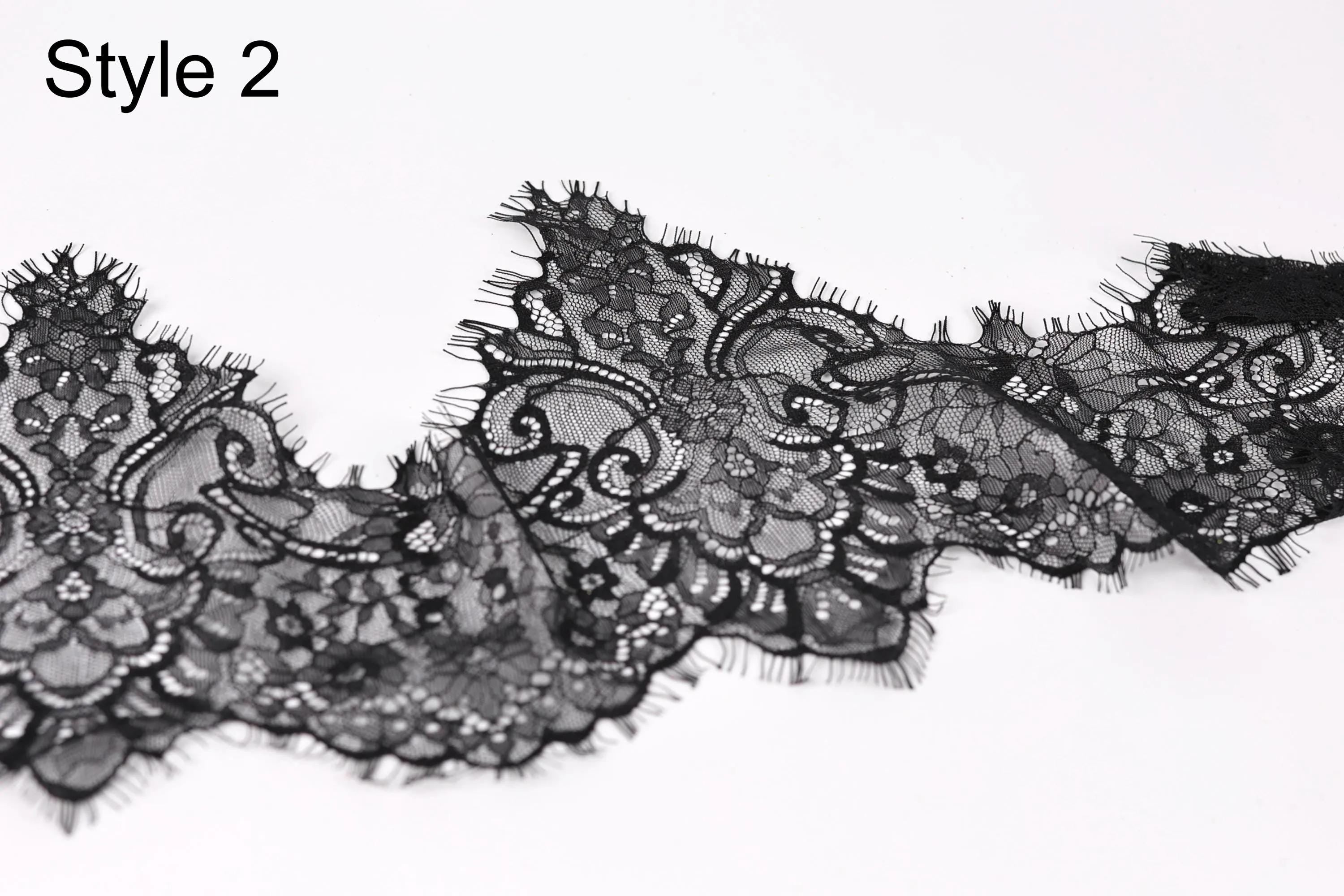 A close-up view of a delicate black lace fabric with intricate floral patterns and textures.
