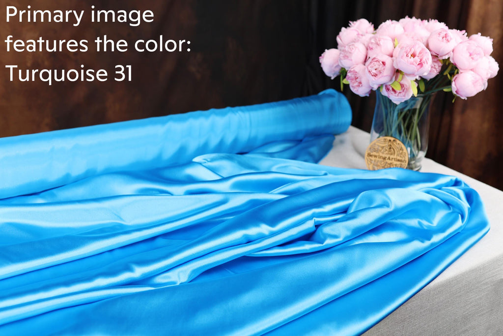a blue satin fabric and a vase of pink flowers, with the text "Primary image features the color: Turquoise 31" overlaid on the image.