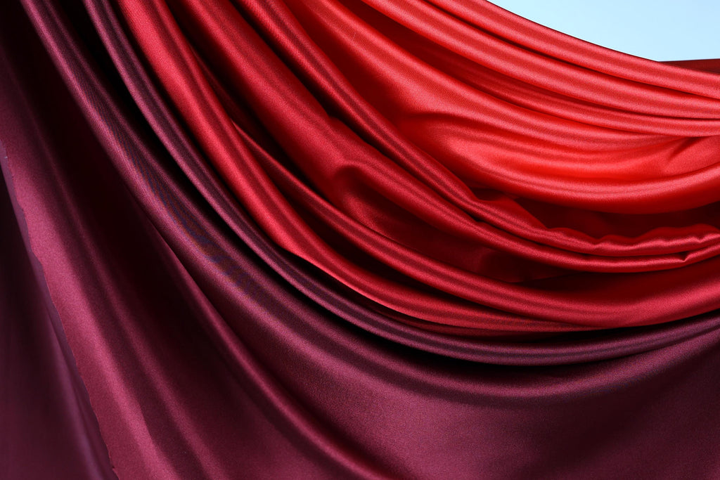 a close-up view of a fabric with a gradient of red and purple colors, creating a visually striking and textured appearance.