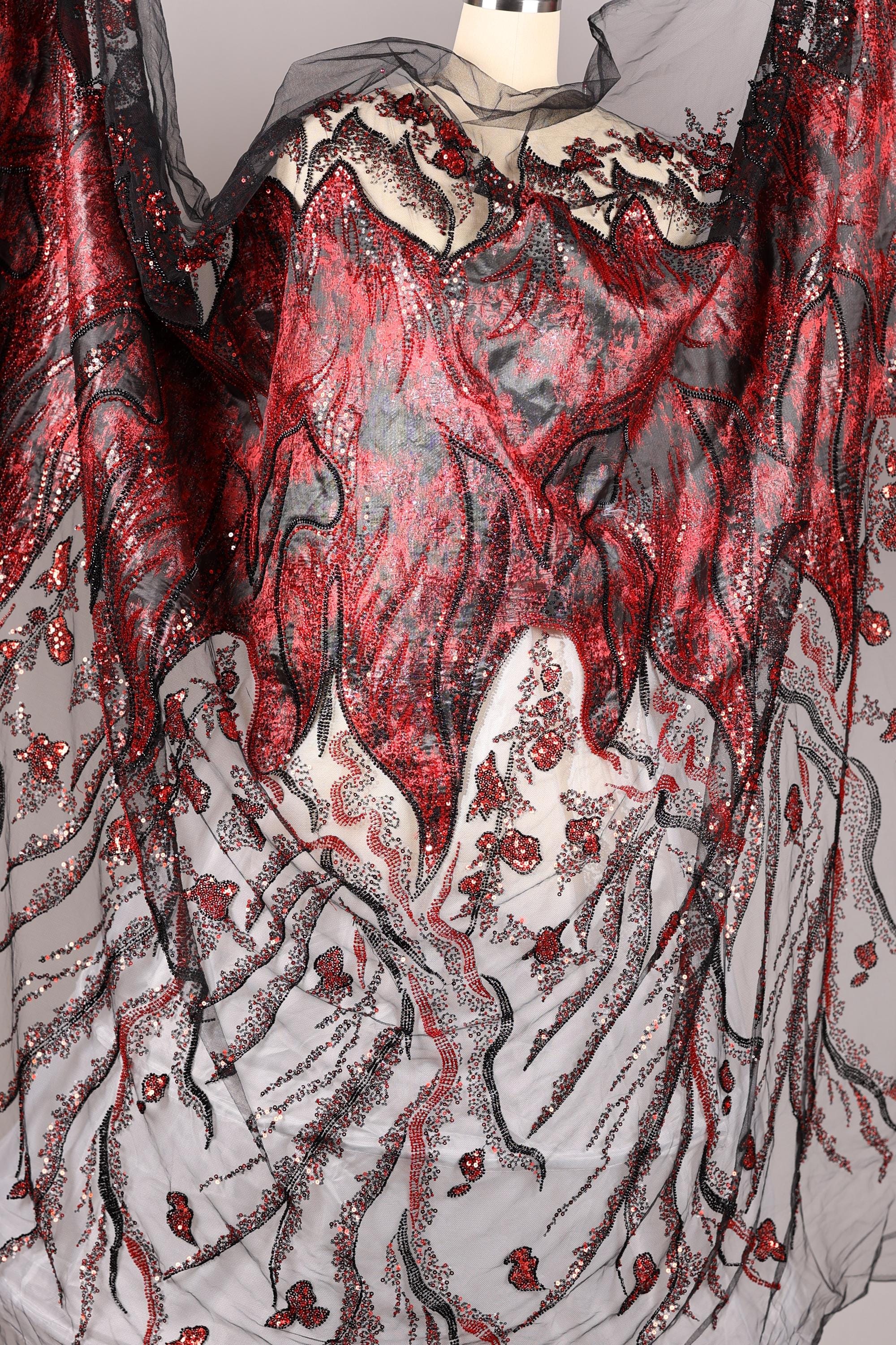 a fabric with a striking red and black pattern, including a mix of floral and abstract designs. The fabric appears to be a sheer material, with a black and white color scheme. The overall composition of the image is visually captivating and intricate.