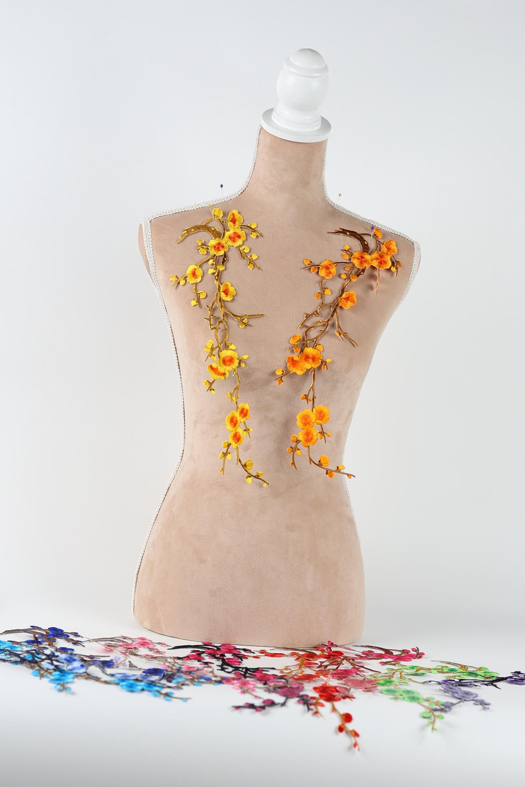 a mannequin with a floral design on its back, including orange and yellow flowers.