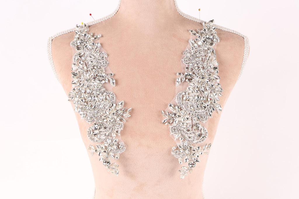 A mannequin torso wearing a necklace with large, sparkling rhinestones or crystals.