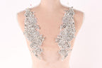 A mannequin torso wearing a necklace with large, sparkling rhinestones or crystals.
