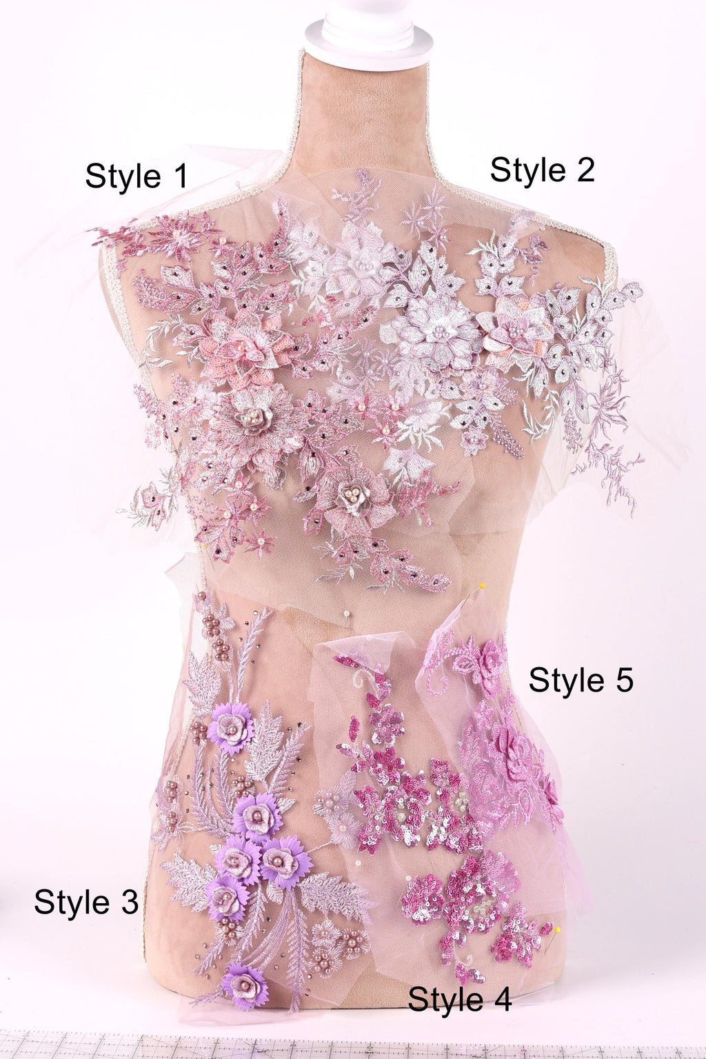 A mannequin with various styles of pink and white floral embroidery displayed on its chest.